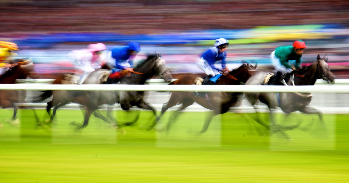 Blurred image of horses racing at Ascot.