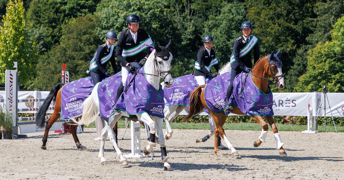 A winning team of four horses and riders during a victory gallop.