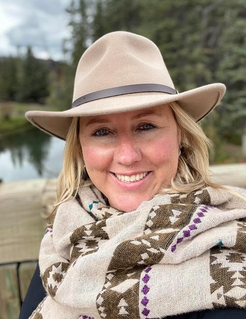 A smiling woman in a cowboy hat.