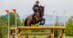 A woman jumping a bay horse over a cross-country fence at Bromont.
