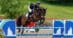 A woman jumping a bay horse over a fence at Bromont.