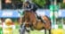A man jumping a bay horse over a fence at Spruce Meadows.