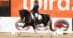 A woman riding a pain horse in para-dressage competition.