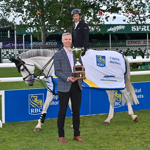 A man on a grey horse during an awards ceremony.