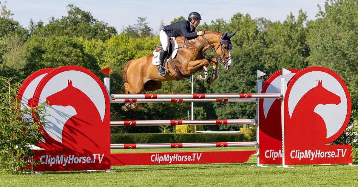A man jumping a chestnut horse over a fence at Hickstead.