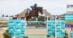 A woman jumping a bay horse over a fence in the UK.