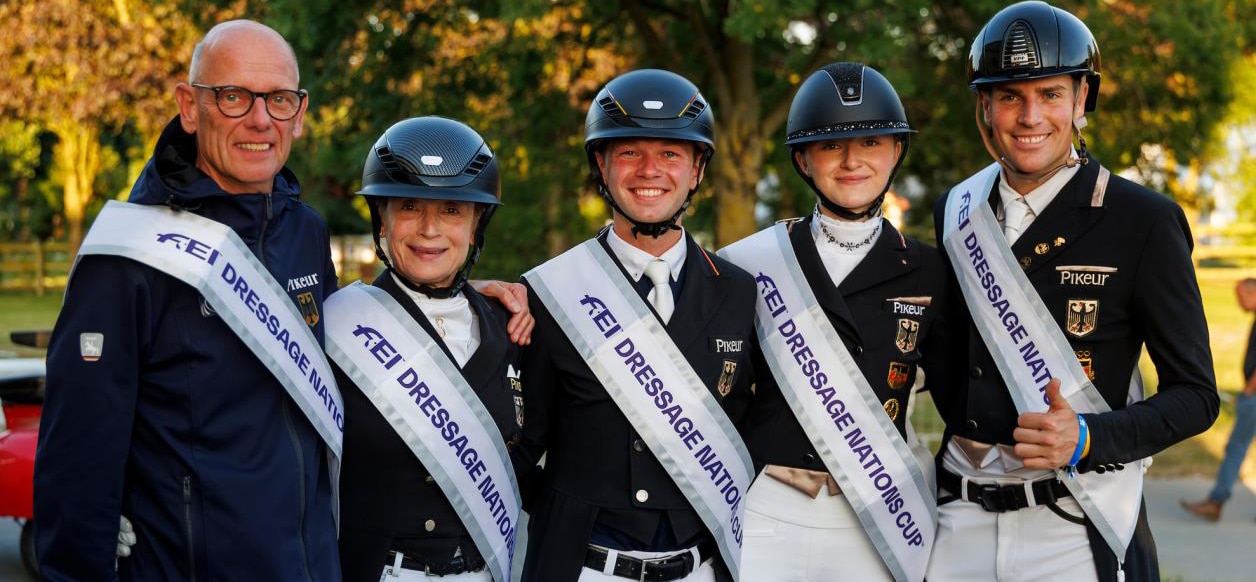 Five smiling people standing on a podium.
