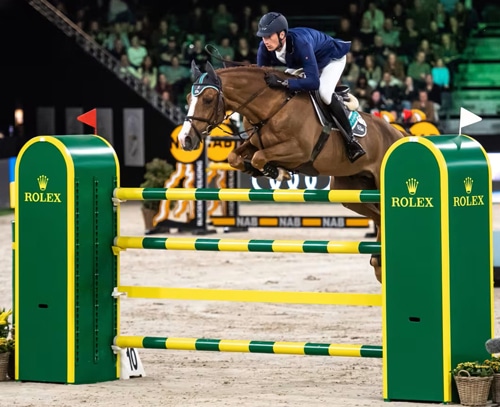 A horse and rider jumping a Rolex fence.