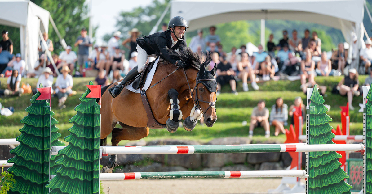 A man jumping a bay horse over a fence at Bromont.
