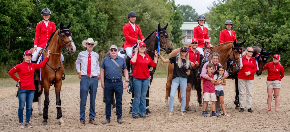 A group of riders and horses and grooms.
