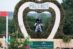 A young man on a grey horse jumping through a heart-shaped keyhole on cross-country.