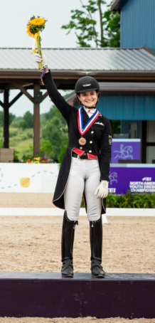 A young woman holding up flowers on a podium.