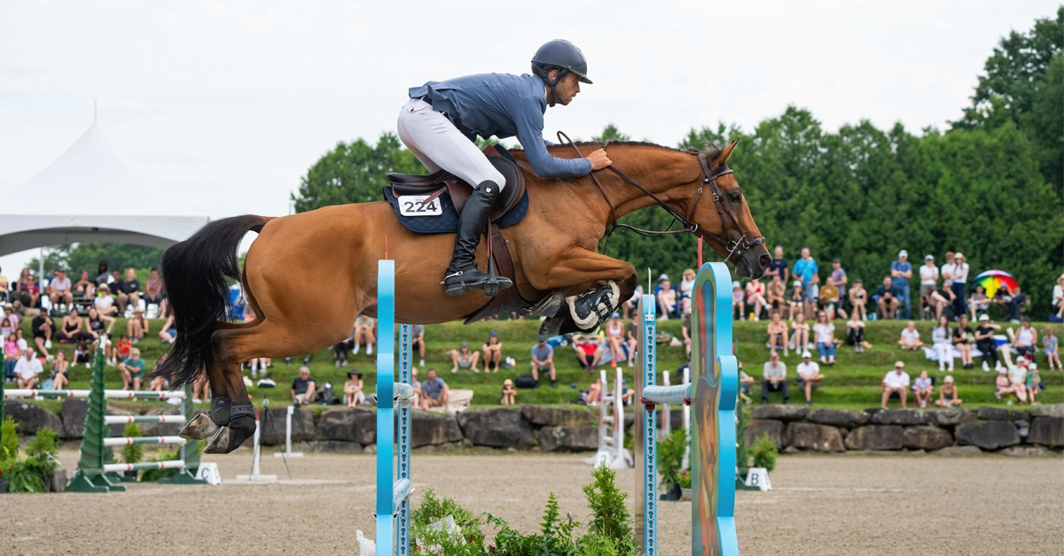 A man jumping a chestnut horse over a fence at Bromont.