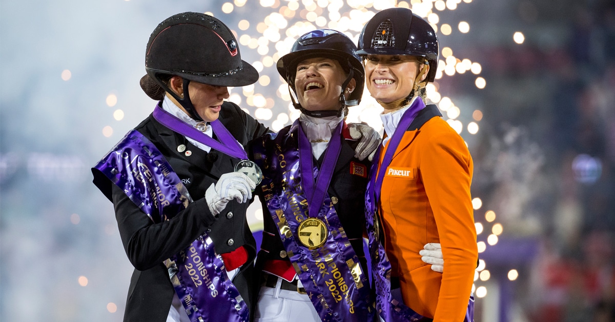 Three women celebrating on a podium.
