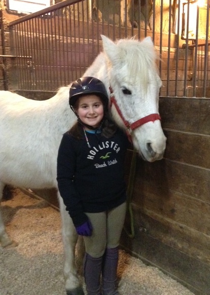 A young girl with a grey pony.