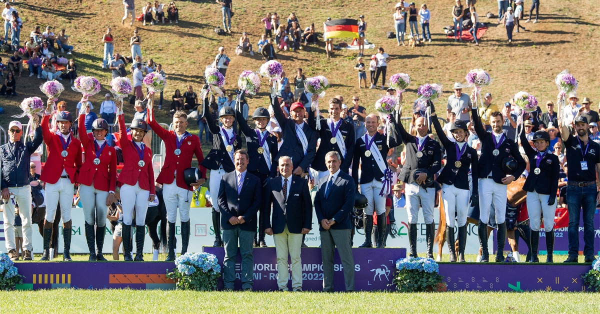 A group of teams waving from a podium.