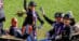 A dressage team waving from an open carriage.
