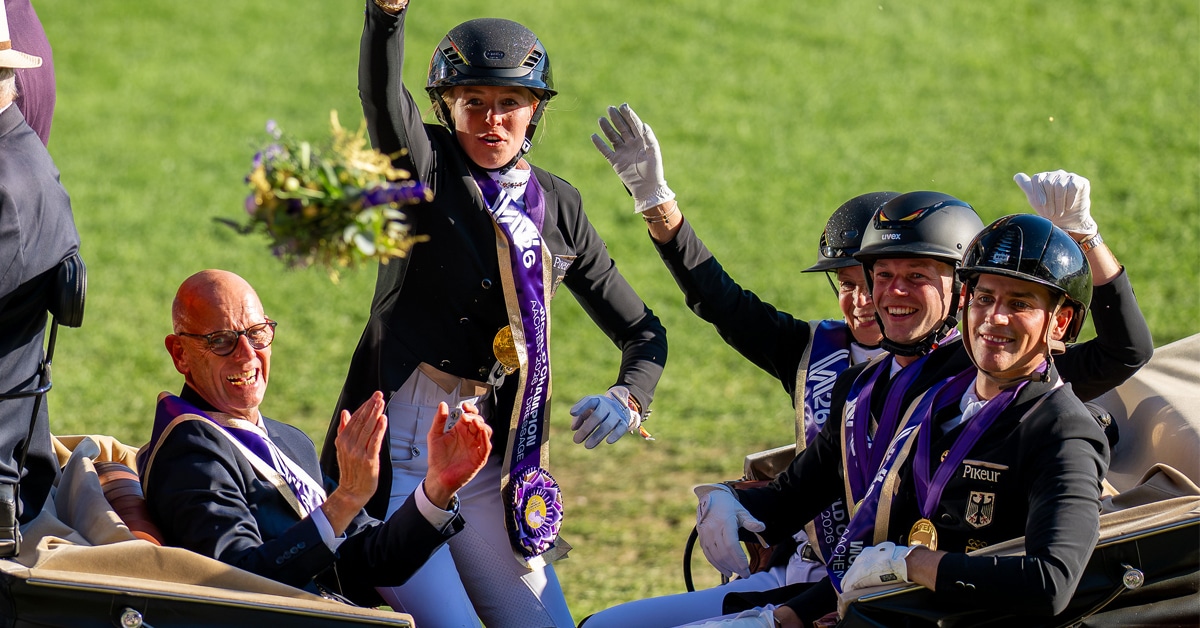 A dressage team waving from an open carriage.