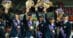 A team on a podium in Denmark, waving flowers.