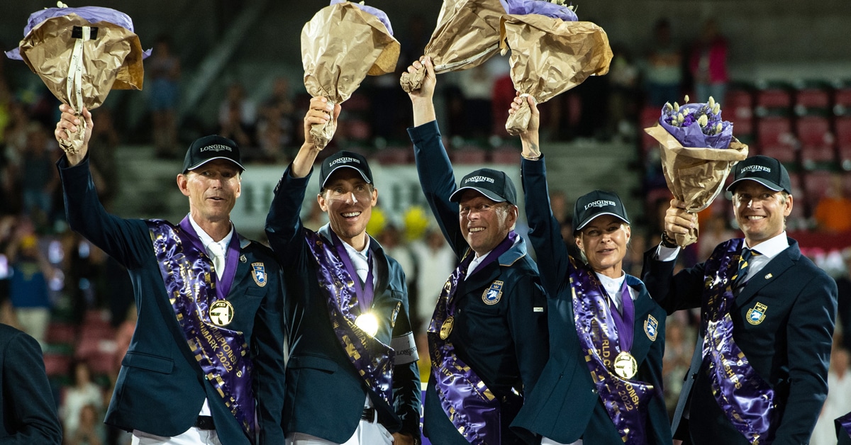 A team on a podium in Denmark, waving flowers.