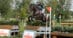 A man jumping a dark bay horse over a cross-country fence.