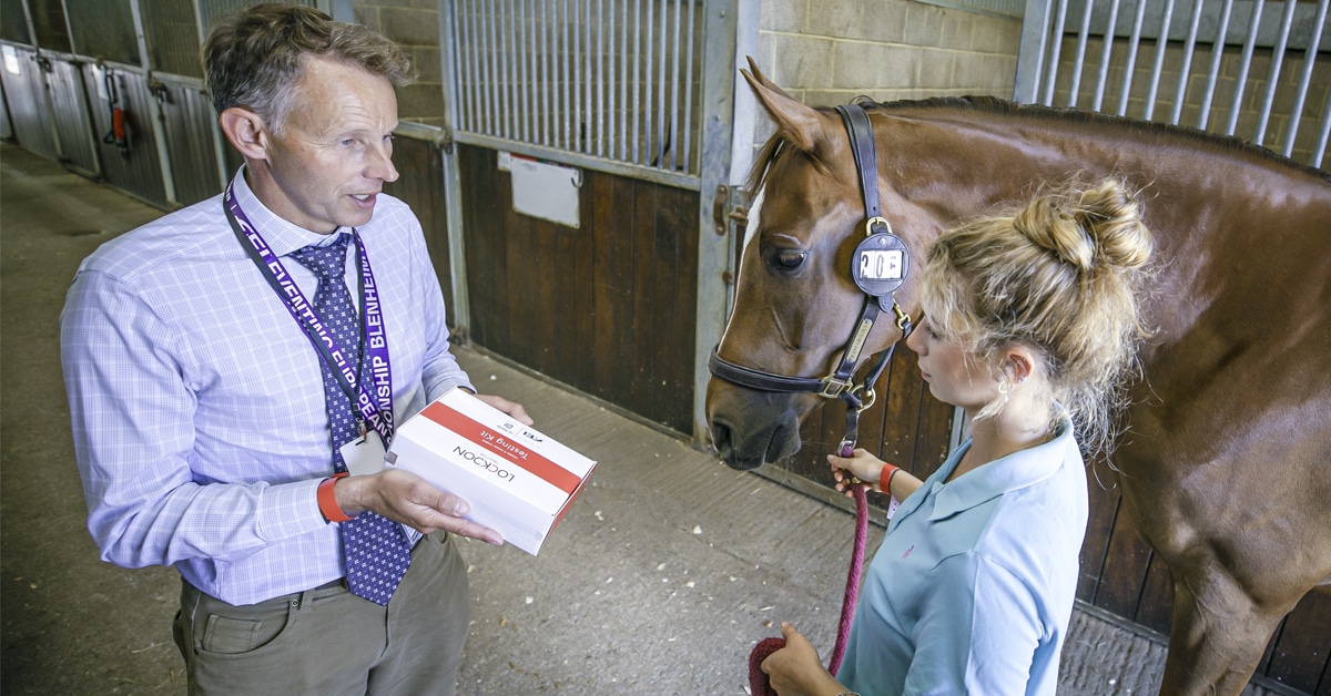 An FEI official showing a testing kit to a groom.