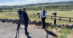 Two women standing beside a field having a discussion on camera.
