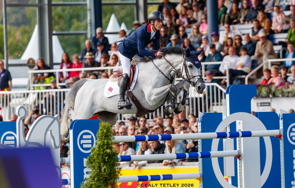 A man jumping a grey mare over a fence in Aachen.