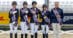 A team of para riders on a podium with hands over hearts.