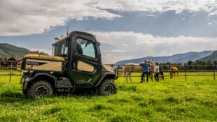 A utility vehicle hauling hay on a horse farm.