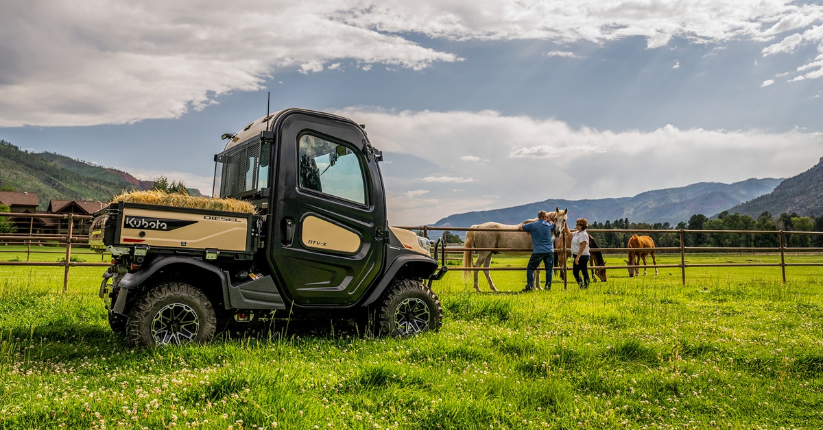 A utility vehicle hauling hay on a horse farm.