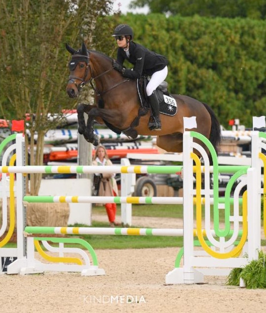A woman jumping a bay horse over a fence in the Hamptons.
