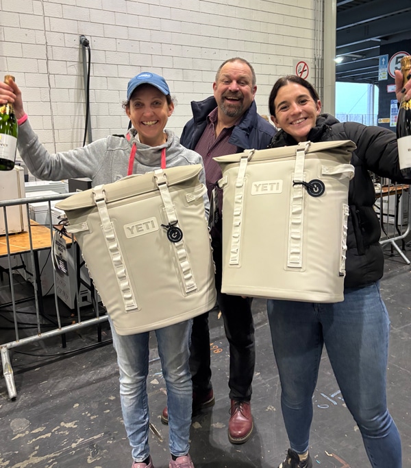 Two smiling grooms with YETI bags.