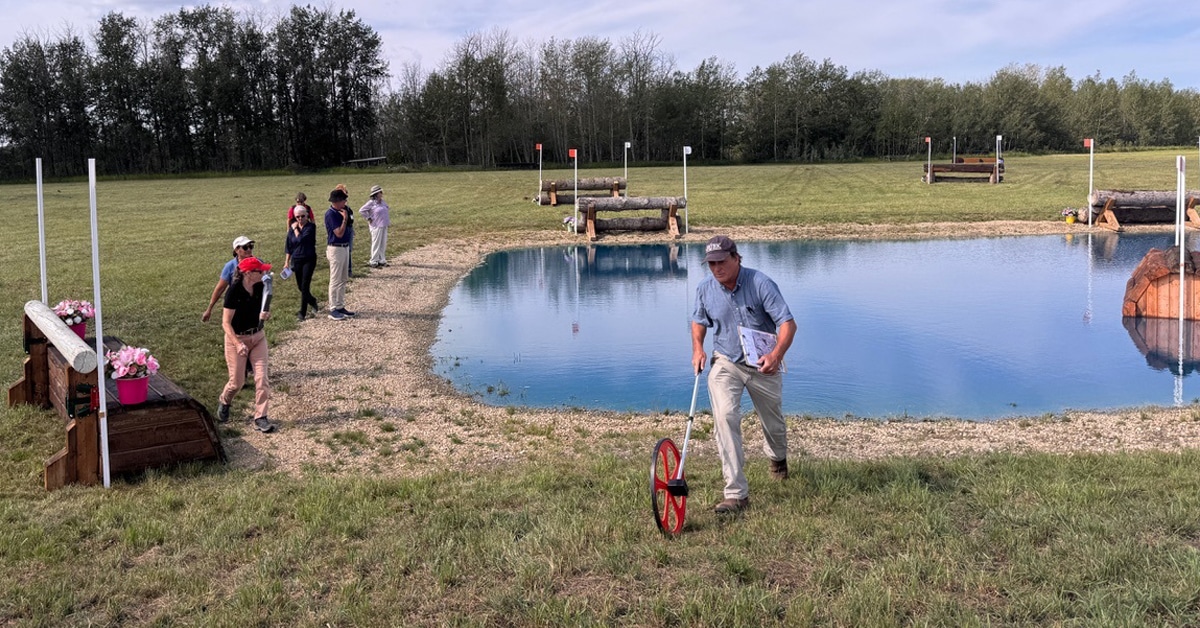 A man measuring a water jump with a wheel.