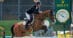 A man jumping a bay horse over a fence at Spruce Meadows.