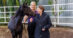 A woman patting a dark bay foal.