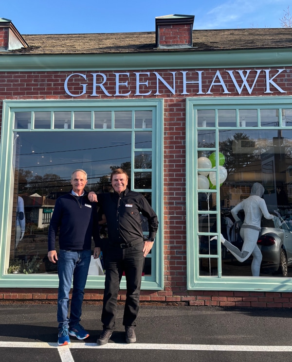 Two men standing in front of a Greenhawk store.