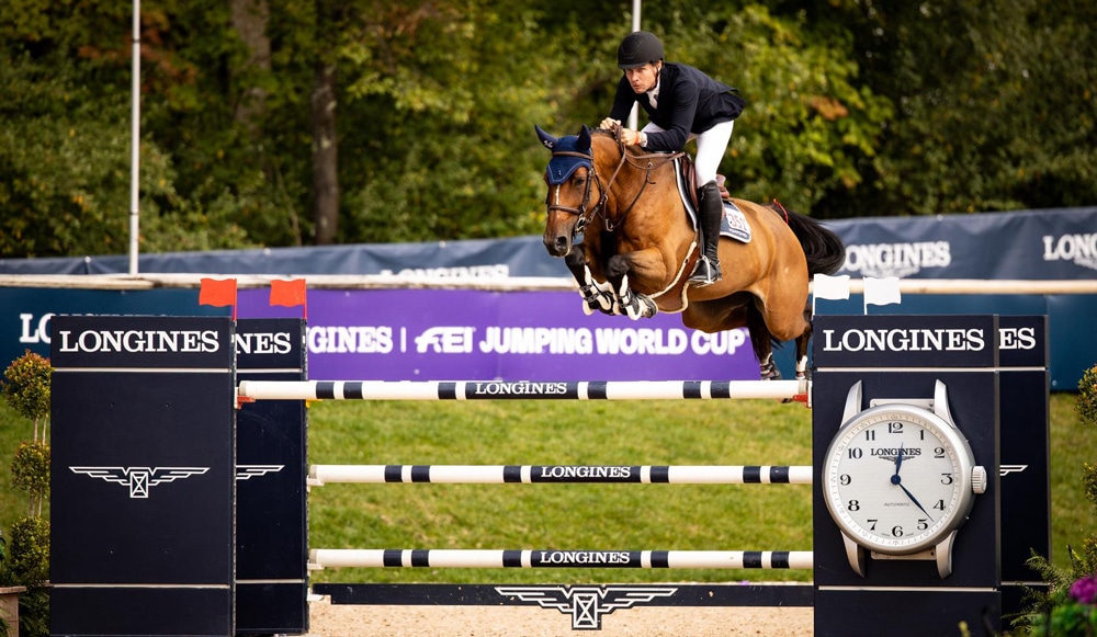 A man jumping a bay horse over a fence at Traverse City.