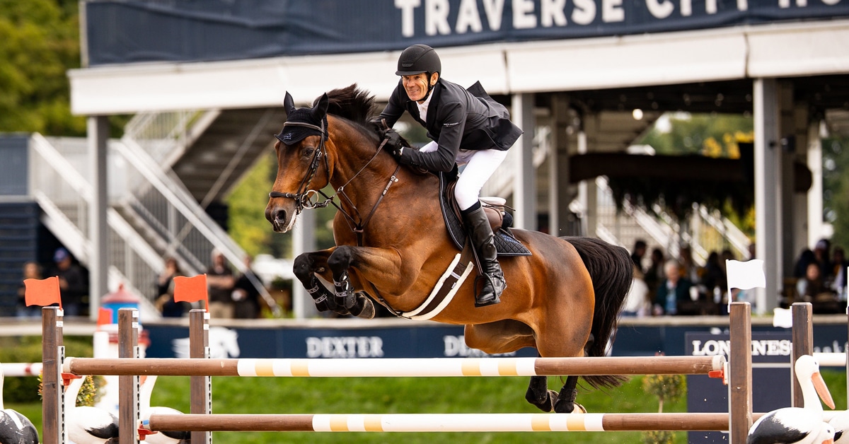 A man jumping a bay mare over a fence at Traverse City.