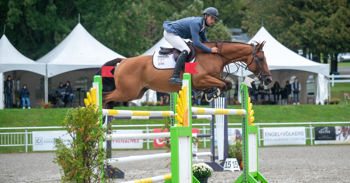 A man jumping a bay horse over a fence at Bromont.