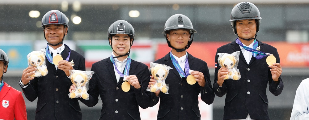 A team with gold medals standing on a podium.