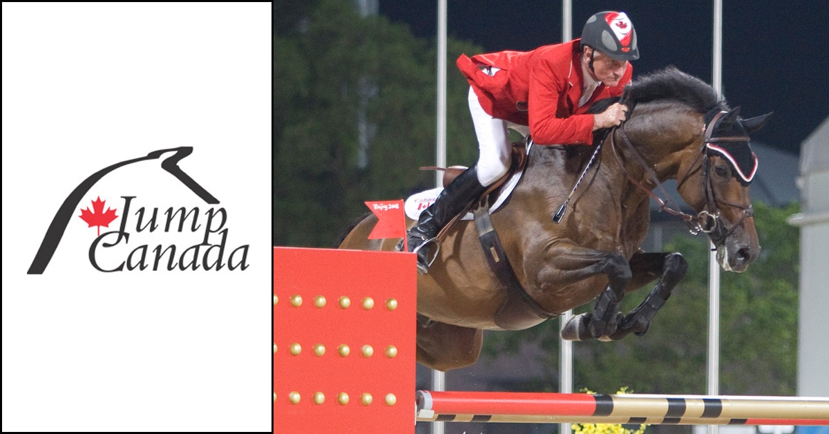 A man wearing a red jacket jumping a bay horse over a fence.