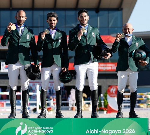 Four smiling men on a podium.