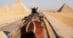 A horse pulling a cart between pyramids in Cairo.