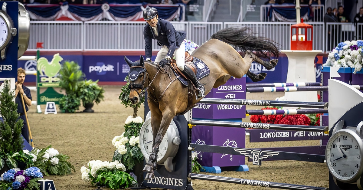 A man jumping a bay horse over a fence at the Royal.