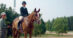 A trainer and a rider on a horse at a show.